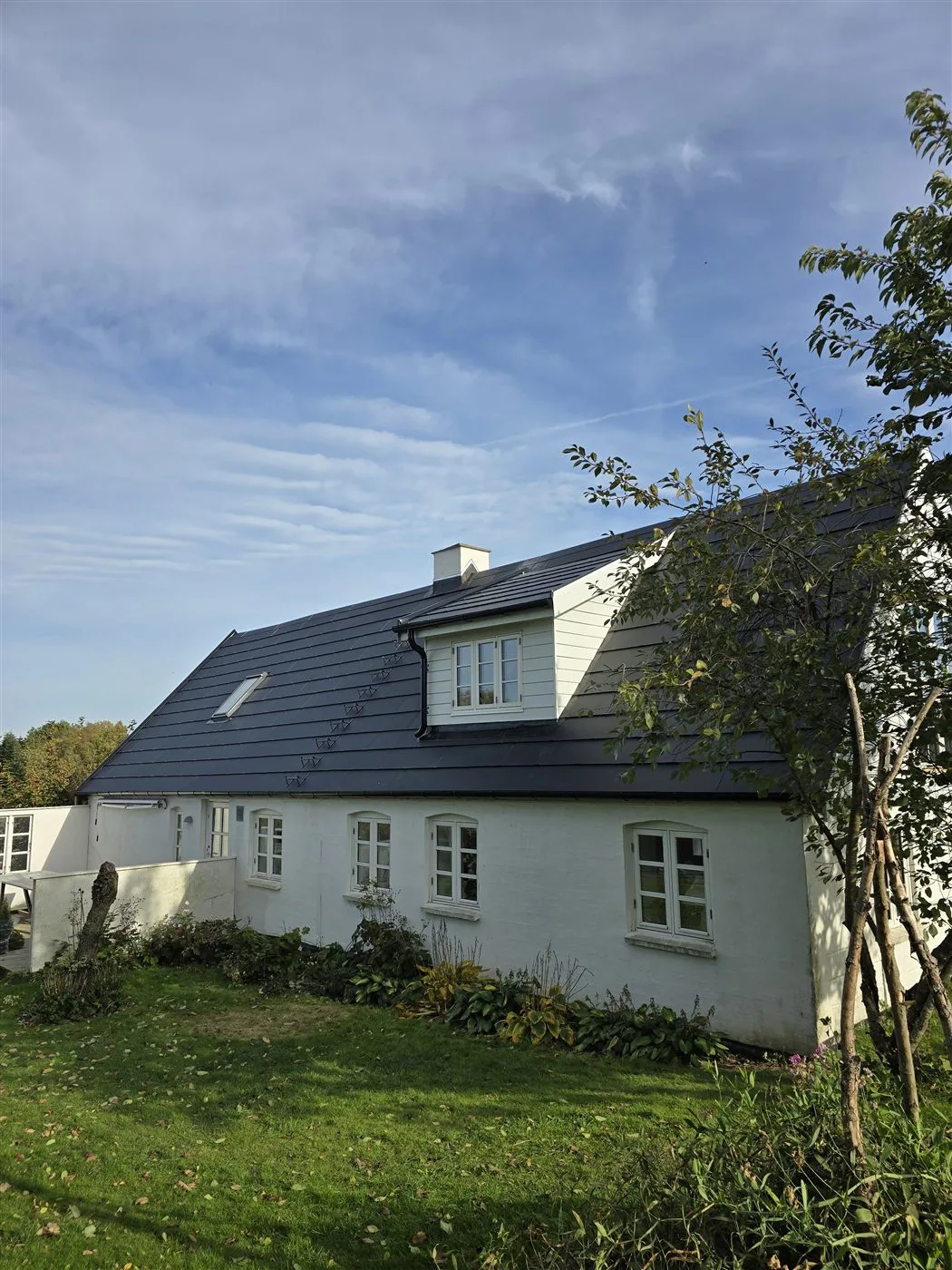 Landsted med sort tag og solceller